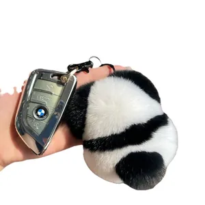 Panda plush keychain made of fluffy fur shown with a car key on a clean background