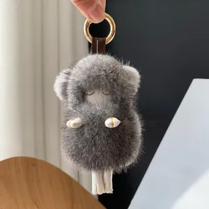 Detailed view of gray mink fur lamb keychain with white leather legs and gold ring