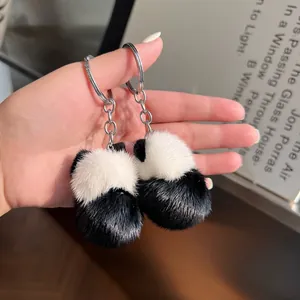 Vue détaillée de deux porte-clés panda en fourrure pelucheuse tenus à la main