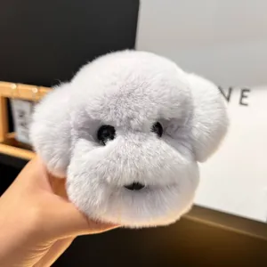 Détail d'un porte-clés peluche tête de chien gris clair sur un sac cadeau élégant