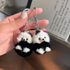 Détail de deux porte-clés panda en fausse fourrure douce avec des anneaux en métal argenté
