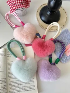 Detail van pluizige hartvormige sleutelhangers van imitatiebont in roze, munt en paars