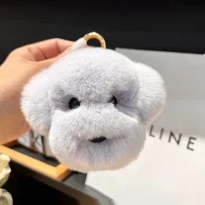 Détail d'un porte-clés chien en peluche violette avec anneau doré sur fond blanc
