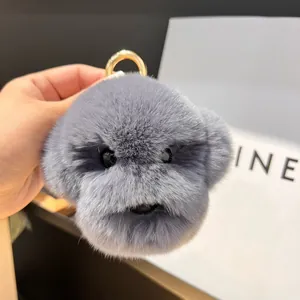 Détail d'un porte-clés chiot en peluche grise avec texture douce et fermoir doré