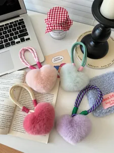 Detailed view of fluffy heart-shaped keychains in pink, mint, purple and rose fur colors