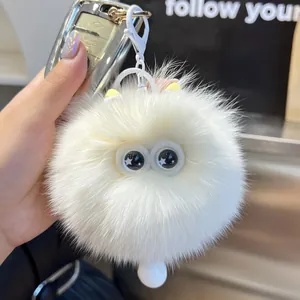 Detail eines flauschigen Plüsch-Kätzchens mit Sternenaugen und gelben Ohren am Schlüssel