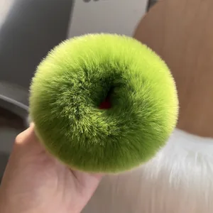 Dettaglio di un elastico per capelli in pelliccia verde con una trama soffice