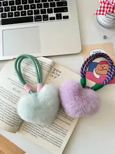 Detailed view of mint green and lavender heart-shaped faux fur charms with woven ropes