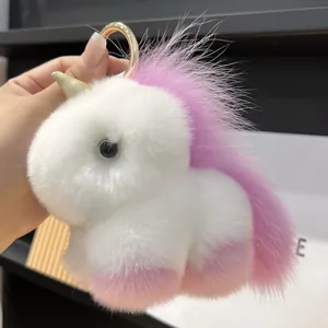 Detail of plush unicorn keychain showing soft white purple fur and golden metal ring