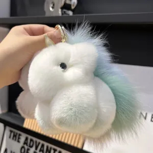 Close-up of soft white plush unicorn keychain with pastel gradient tail and golden ring