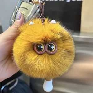 Nahaufnahme eines flauschigen orangefarbenen Monster-Schlüsselanhängers mit großen Augen