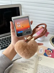 Detail of plush brown faux fur heart charm and thick braided lanyard for folding phone