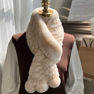 Detail of a creamy white rabbit fur scarf with thick texture and crossover style on a mannequin