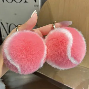 Détail de porte-clés balle de tennis en peluche rose et blanc avec texture douce