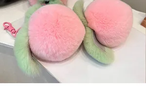 Close-up of soft plush peach keychain with pink fluffy faux fur and green leaf detail