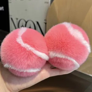 Gros plan de breloques de tennis en peluche rose et blanc en véritable fourrure de lapin