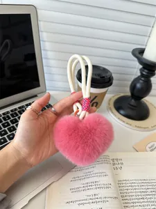 Pink heart-shaped faux rabbit fur plush charm with orange buckle on white cord