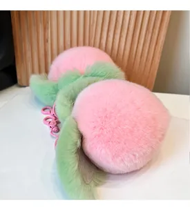 Close-up of two soft pink plush peach keychains with fuzzy leaves and metal hooks