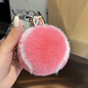 Porte-clés balle de tennis en fourrure rose avec anneau doré sur une clé de voiture
