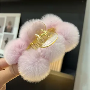Close-up of pink faux rabbit fur plush hair claw clip with soft pompom texture