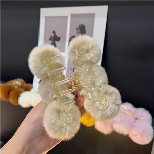 Plush faux fur ball hair claw clip in beige, available in multiple winter colors