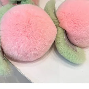 Cute pink plush peach keychain accessory with green leaves on white background