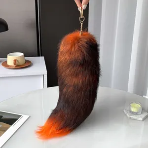 Faux fox tail keychain featuring an orange gradient fur design with gold metal clip