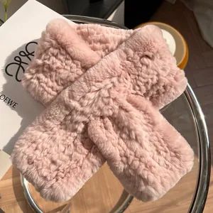Détail d'une écharpe en fourrure de lapin rose avec design croisé sur table en verre