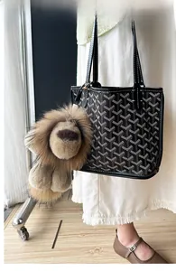 Détail de la peluche lion duveteuse avec fermoir en métal doré sur un sac