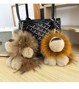 Détail de porte-clés lion en peluche marron et jaune sur bois avec chaîne métallique