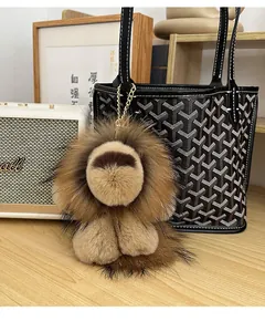 Porte-clés lion en peluche marron duveteuse attaché à un sac à main de créateur chic