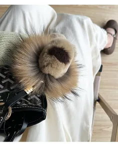 Vue détaillée du porte-clés lion bicolore en fourrure duveteuse sur un sac de créateur