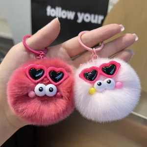 Detail of pink and rose plush fur keychains with heart sunglasses and big eyes charms