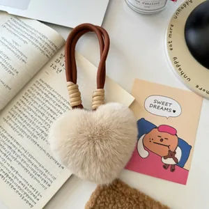 Plush heart-shaped keychain with rabbit fur texture and brown braided strap for bags