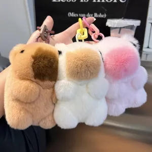 Detail der flauschigen Wasserschwein-Anhänger in Braun, Weiß und Rosa aus weichem Plüsch