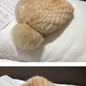 Detailed close-up of thick knit mink fur hat texture with fluffy fox fur pompom in camel color