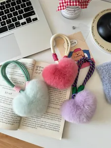 Detail van pluche hartvormige sleutelhangers in munt, roze en lila met geweven lussen