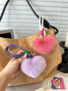 Detail van de pluche hartvormige tassenhangers in roze en paars met geweven koordjes
