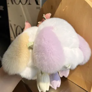 Plush white bunny keychain with colorful ears and tulip pendants held by hand