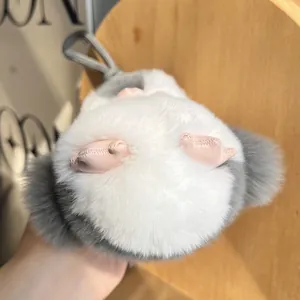 Dettaglio del ciondolo a pinguino in peluche grigio e bianco con dettagli rosa