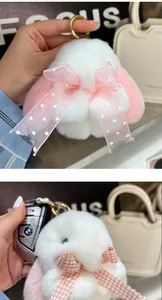 Nahaufnahme vom Plüsch-Hasen-Schlüsselanhänger mit rosa Schleifen und Metallclip