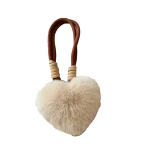 Beige hartvormige sleutelhanger van imitatiebont met bruin gevlochten koord hangend