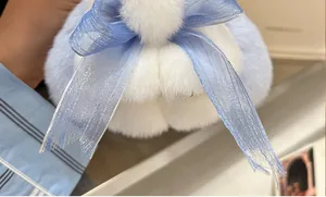 Nahaufnahme vom weichen hellblauen Plüsch-Schlüsselanhänger mit Organza-Schleife