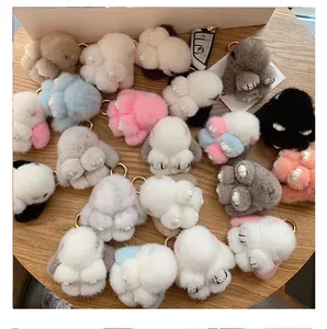 Macro detail of plush faux fur rabbit charms with rhinestone paws and gold keyrings