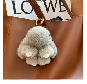 Detail of soft grey mink fur bunny bag charm featuring gold ring and leather strap