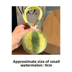 Detail shot of a 9cm plush watermelon charm with yellow and green striped rabbit fur
