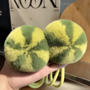 Detailed close-up of fluffy yellow and green spiral rex rabbit fur pom pom hair ties