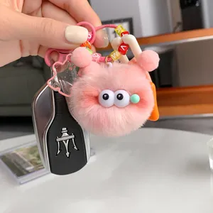 Cute pink plush monster keychain with big eyes and letter beads hanging on car keys