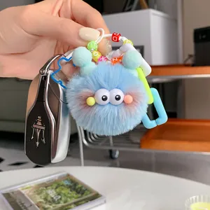 Detailed macro view of a blue faux mink fur monster keychain with colorful letter beads