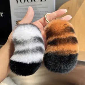 Detail of soft striped rex rabbit fur tiger tail keychains with golden metal rings